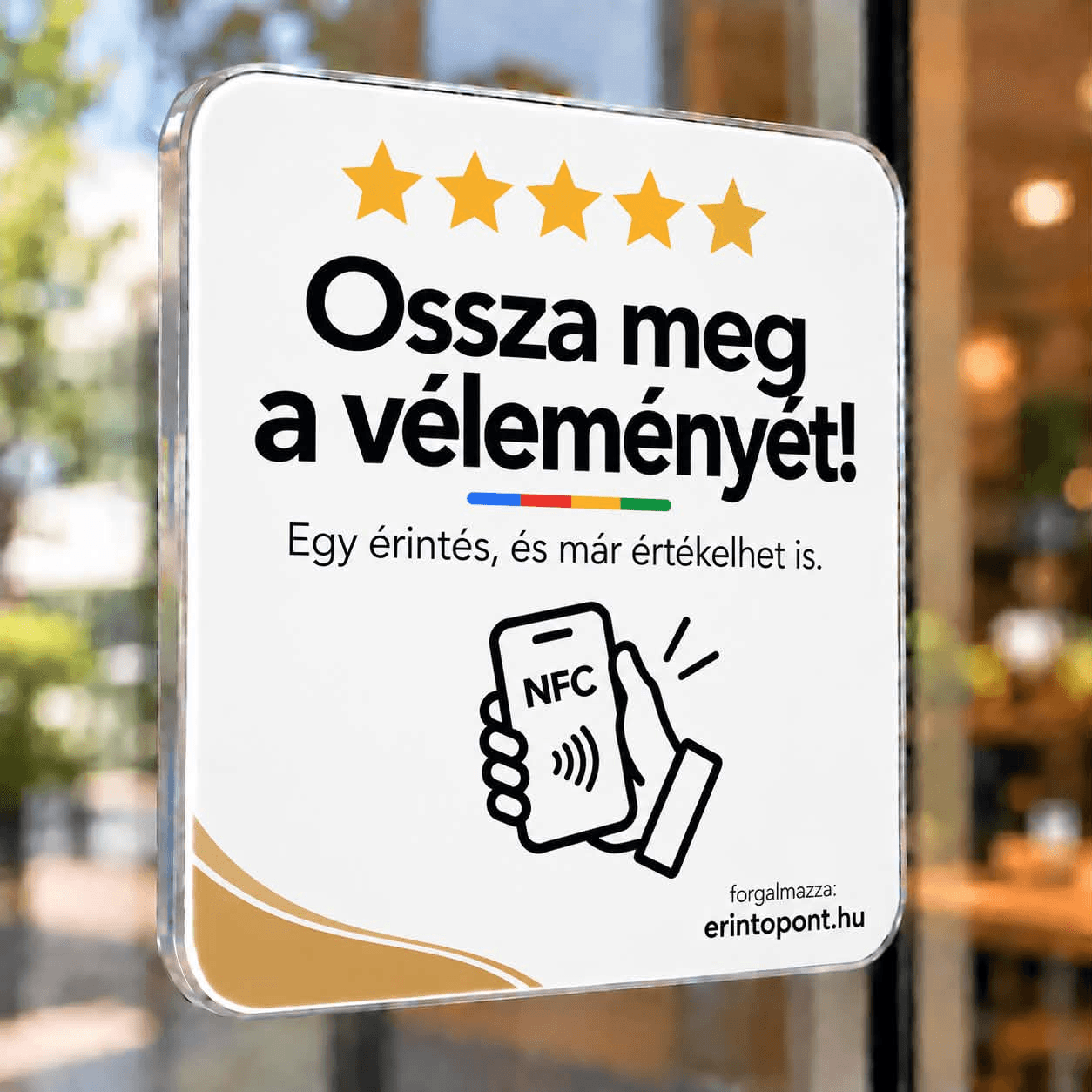Fehér, arany díszítésű, „Ossza meg a véleményét!” feliratú NFC tábla egy kávézó ablakán